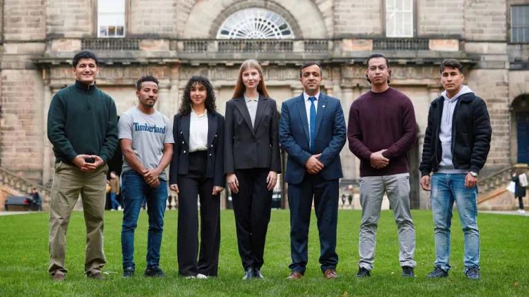Seven people from Education Beyond Borders standing outside of the University's Old College.