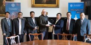 James Smith exchanges gifts with representatives from MoRA, IIIU, and the British Council