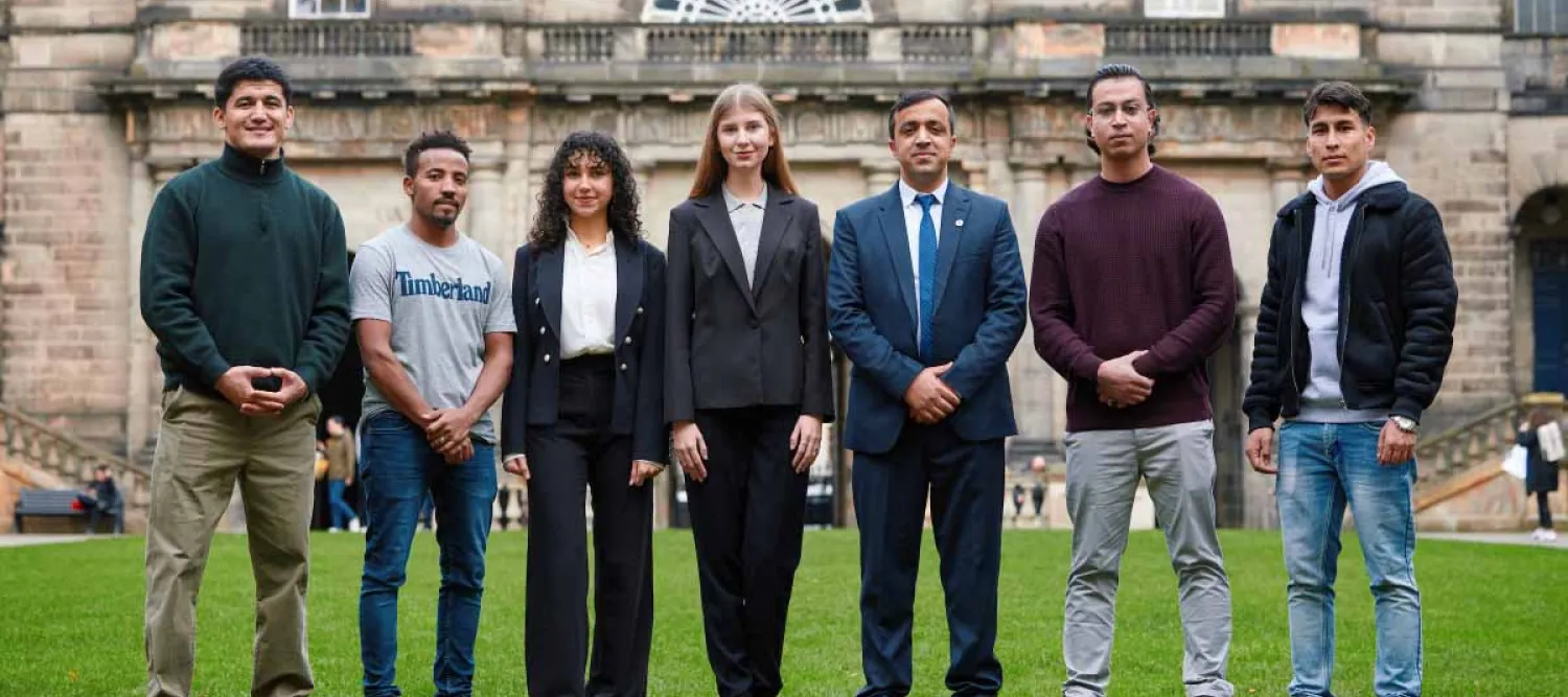 Seven people from Education Beyond Borders standing outside of the University's Old College.