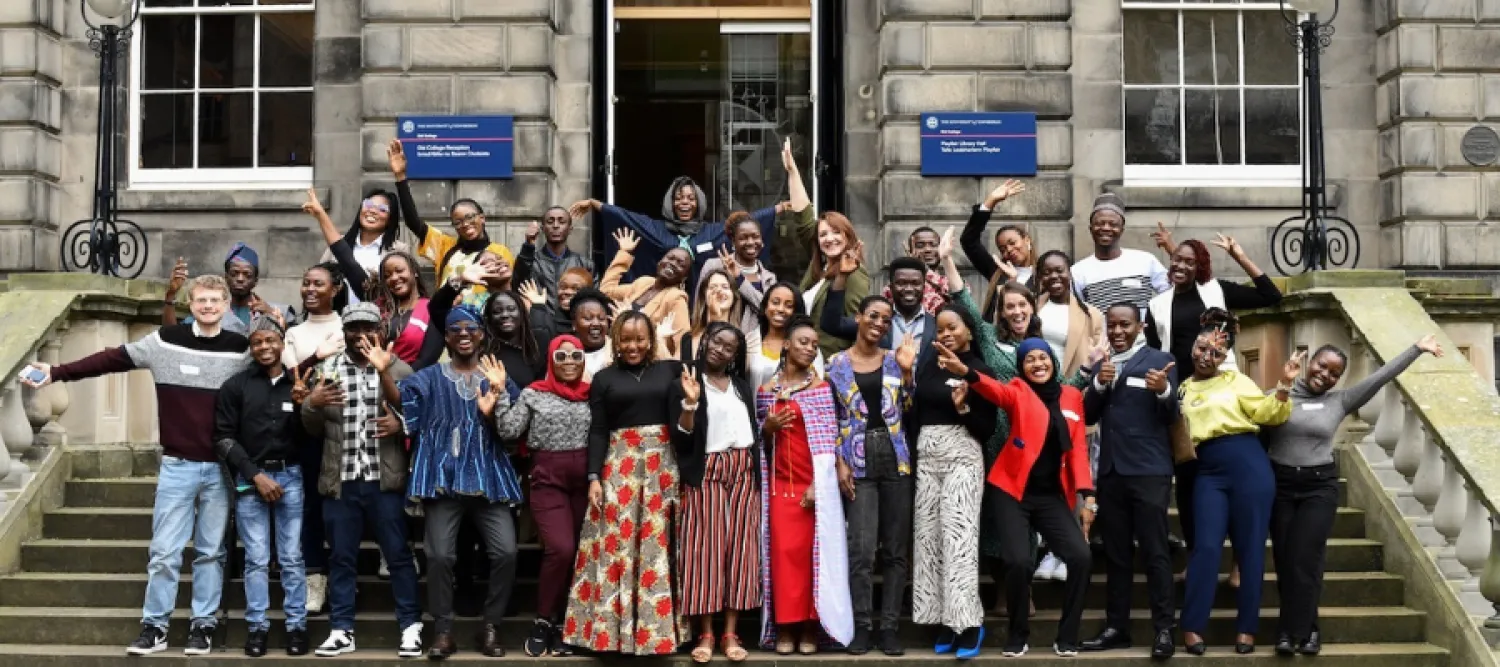 Large group of MCF staff and scholars posing happily at Old College