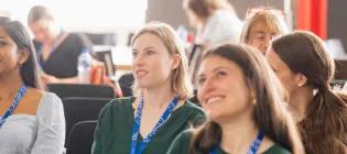 Staff smiling during Una Europa general assembly at a presentation