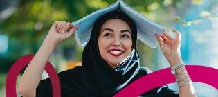 Smiling scholar holding book over her head