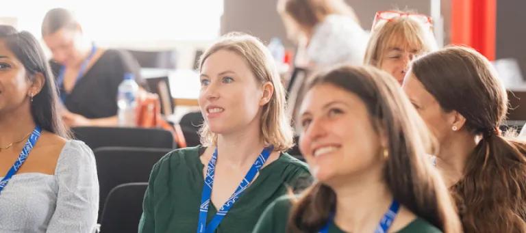 Staff smiling during Una Europa general assembly at a presentation