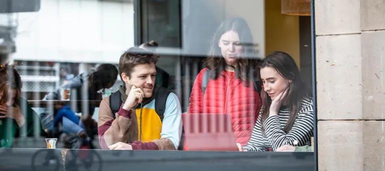 Three students looking at a computer.