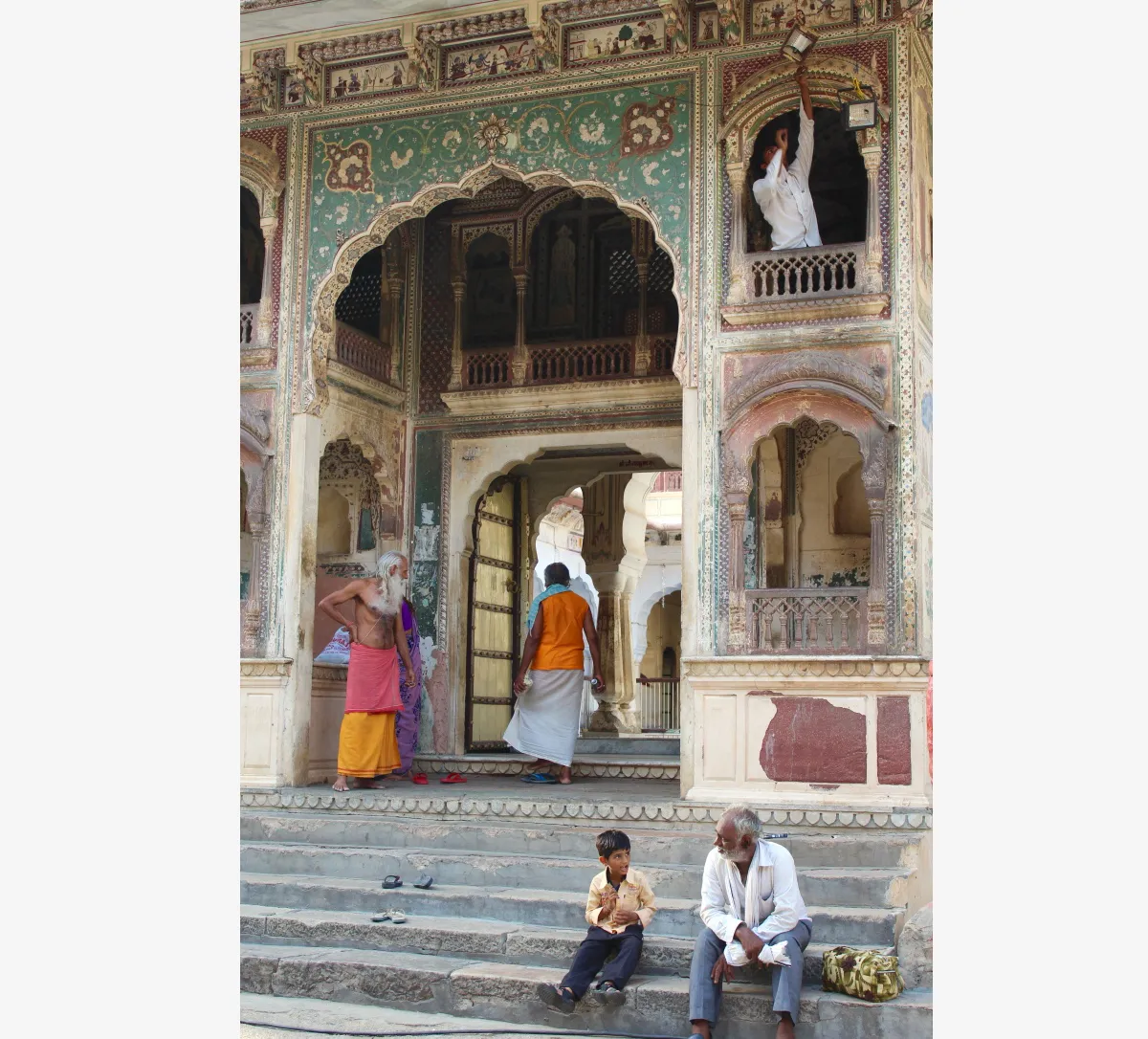 people sitting on steps of a temple