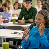 Student with microphone asking a question is lecture