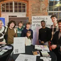 Student and staff promoting Una Europa at event with banners