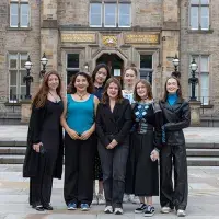 Seven students standing in front of the Edinburgh Futures Institute.