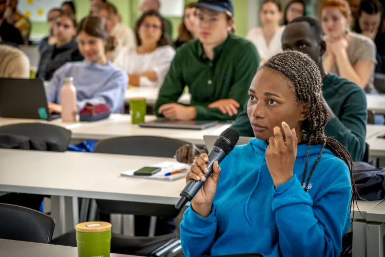 Student with microphone asking a question is lecture