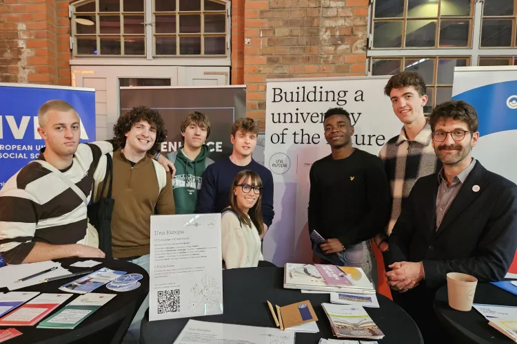Student and staff promoting Una Europa at event with banners