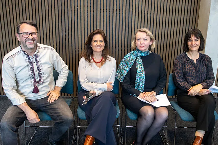 Four professionals sitting and smiling at the camera.