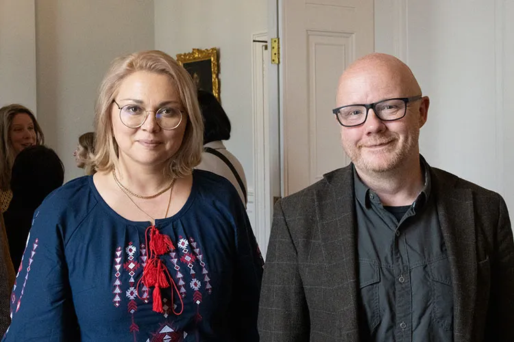 James Smith and Kseniia Smyrnova smiling at the camera.