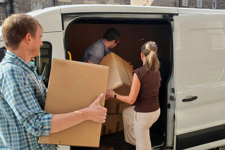 Staff loading boxes into a white van