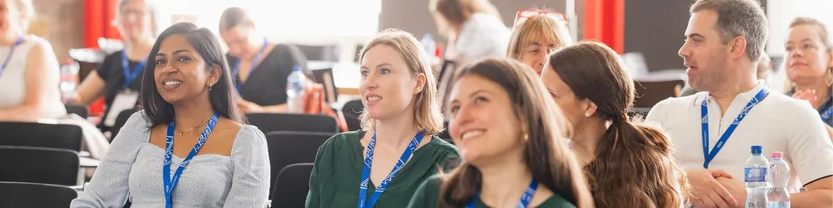 Staff smiling during Una Europa general assembly at a presentation