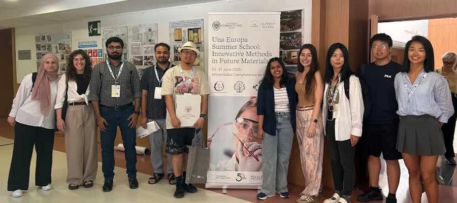10 students smiling and standing around a banner that reads "Una Europa Summer School: Innovative Methods in Future Materials".