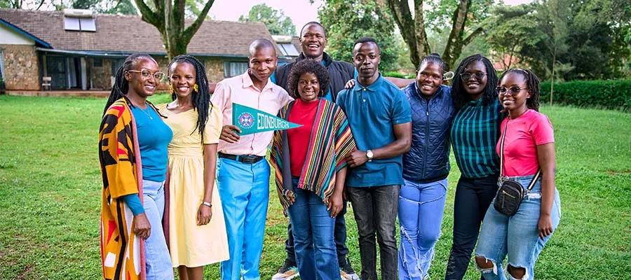 A group of people standing outside and smiling at the camera.