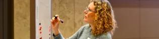 A women writing on a whiteboard