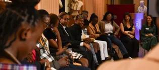A group of Mastercard Foundation Scholars and staff sitting and talking at an event.