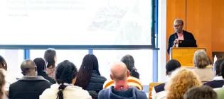 Ivy Mwai presenting a slideshow to a room of people.